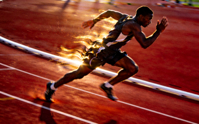 田径运动员在跑道上冲刺的侧面动态照片